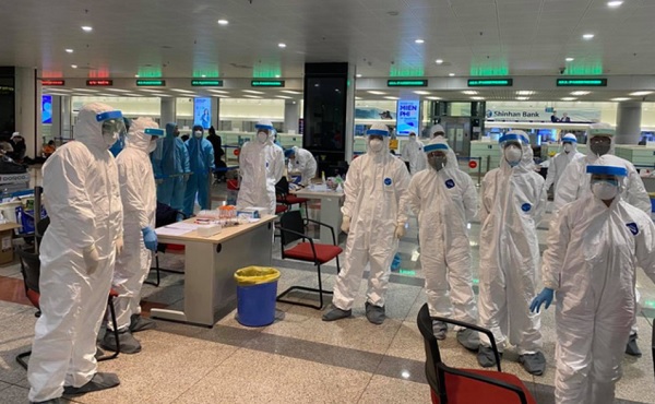 Lực lượng y tế thực hiện việc lấy mẫu bệnh phẩm cho các hành khách tại Cảng hàng không quốc tế Nội Bài