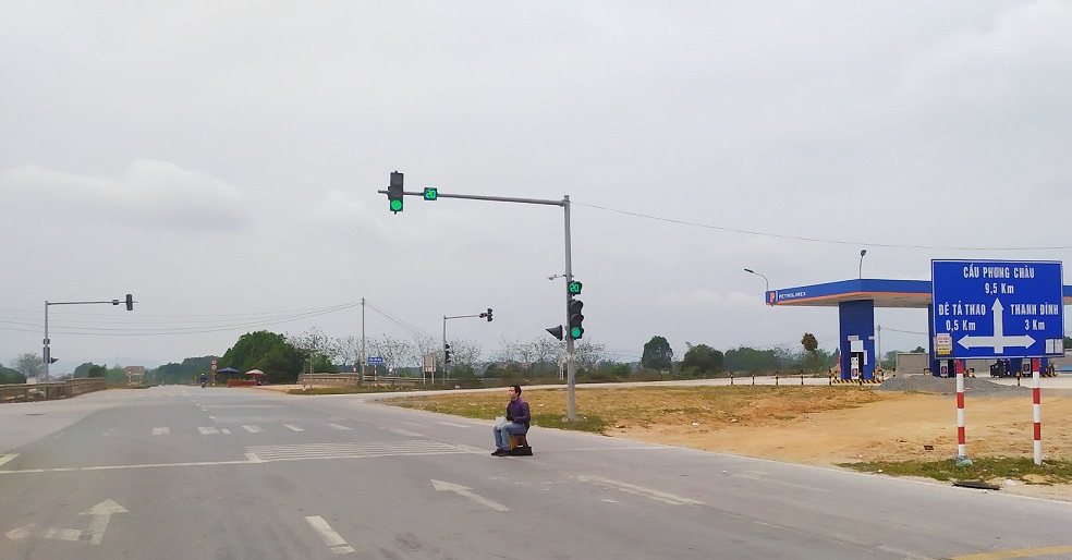 Một người ăn mày ngồi giữa đường Quốc Lộ 32C, đoạn giáp ranh thành phố Việt Trì với huyện Lâm Thao.