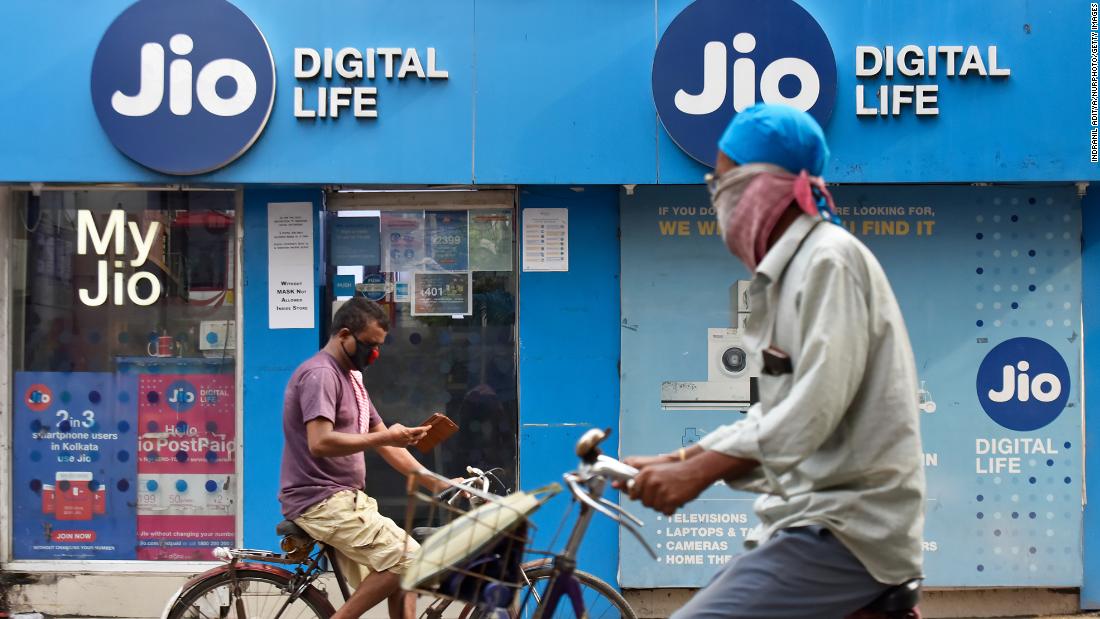 Những người đi xe đạp ngang qua một cửa hàng Jio ở Kolkata, Ấn Độ vào ngày 13/7/2020.
