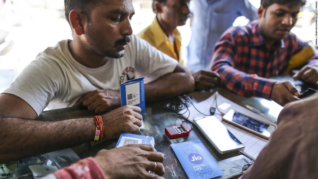 Một khách hàng cầm gói thẻ SIM trong khi chờ kết nối điện thoại di động của mình với nhà mạng Reliance Jio, mạng di động của Reliance Industries, tại một cửa hàng ở Mumbai, Ấn Độ, vào ngày 24 tháng 10 năm 2016.