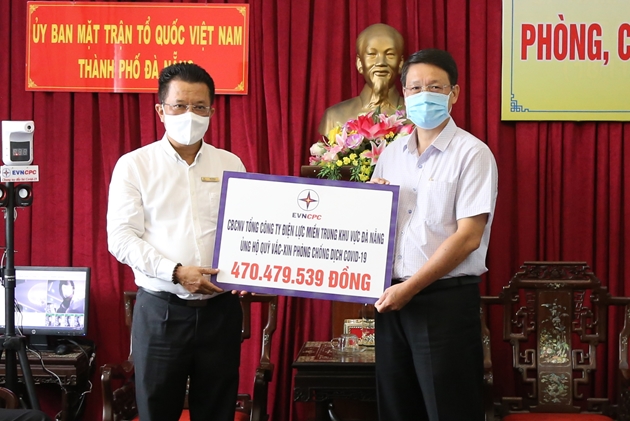 Tổng Giám đốc EVNCPC Ngô Tấn Cư (bên trái) trao bảng tượng trưng kinh phí hỗ trợ mua vắc xin phòng, chống Covid-19