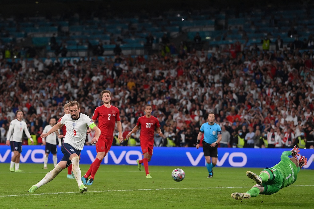 Kane (trái) đá bồi sau khi thực hiện quả phạt 11m bị thủ môn tuyển Đan Mạch cản phá