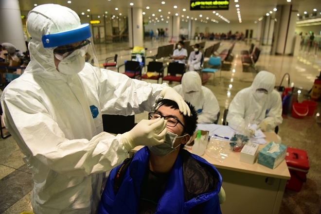 700 sinh viên, 280 y bác sĩ về hưu tình nguyện tham gia chống dịch
Nhân viên y tế lấy mẫu xét nghiệm tại chỗ ở sân bay Nội Bài. Ảnh: CAND