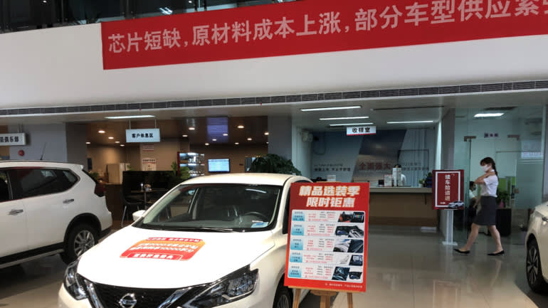 Một biểu ngữ màu đỏ thông báo cho khách hàng về tình trạng thiếu hụt tại một đại lý Nissan Motor ở Quảng Châu. (Ảnh của Takashi Kawakami)