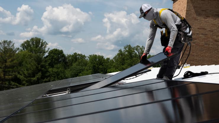 Một nhân viên của Ipsun Solar lắp đặt các tấm pin mặt trời trên mái nhà thờ Peace Lutheran ở Alexandria, Virginia vào ngày 17/5/2021.