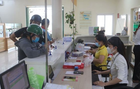 Nhân viên, giao dịch viên Bưu điện huyện Châu Thành đeo khẩu trang khi giao dịch với khách hàng, nhằm chung tay phòng, chống dịch COVID-19