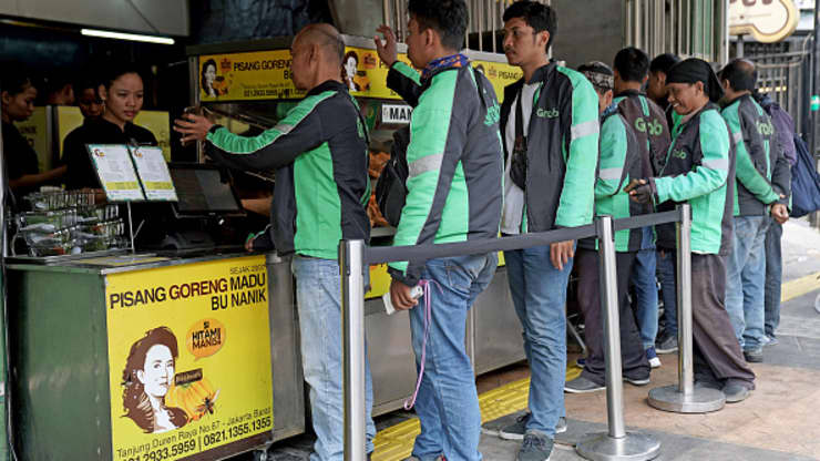 ác tài xế GrabFood xếp hàng dài để nhận đơn hàng tại một cửa hàng Pisang Goreng Bu Nanik ở Jakarta, Indonesia (Nguồn: BLOOMBERG).