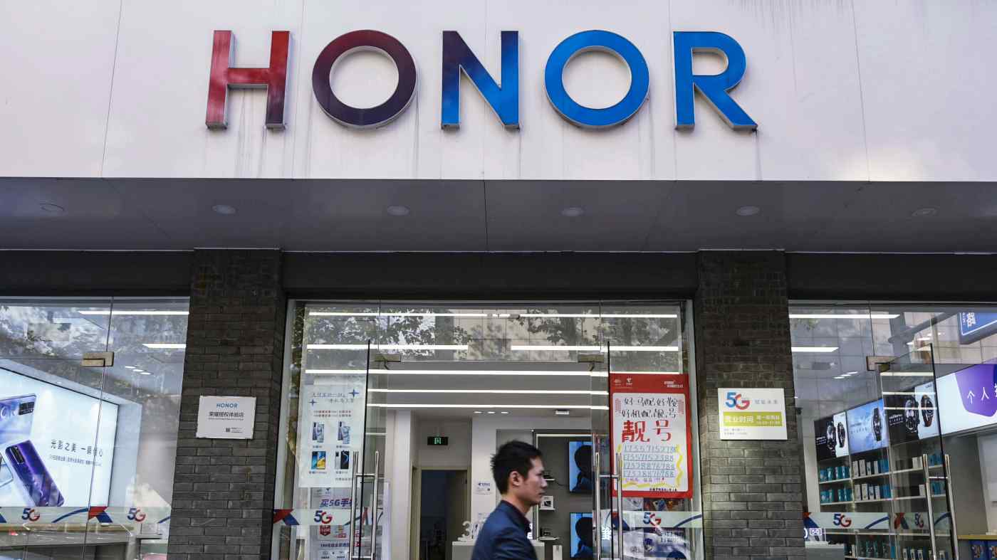 Một người đi bộ đi ngang qua cửa hàng Honor ở Trung Quốc. Công ty điện thoại thông minh đã tách khỏi Huawei Technologies để tránh sự kiểm soát xuất khẩu của Hoa Kỳ đối với các thành phần quan trọng. © Hình ảnh Getty