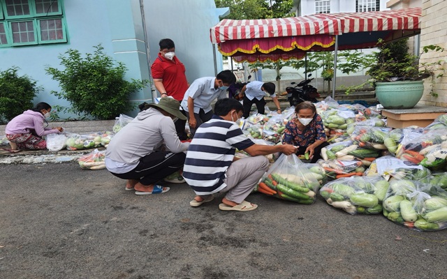 Chính quyền các địa phương tại Bình Dương phân loại rau củ quả, thực phẩm vào từng túi rồi đi phân phát cho các hộ dân