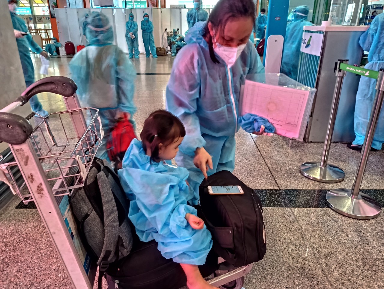 Hai mẹ con dắt díu nhau xuống sân bay Ảnh: Mỹ Dung
