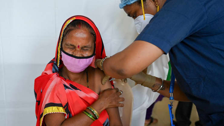 Một phụ nữ phản ứng khi được tiêm một liều vắc xin Covishield chống lại Covid-19 tại một trung tâm tiêm chủng ở Mumbai vào ngày 12 tháng 8 năm 2021.