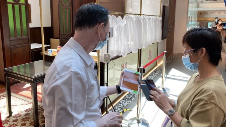 Một nhân viên nhà hàng kiểm tra tình trạng tiêm phòng của một khách hàng ở Singapore. (Ảnh của Takashi Nakano)