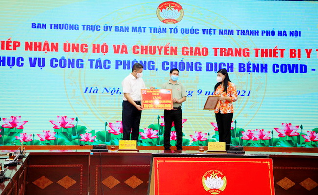 Ông Phạm Ngọc Minh - Công ty TNHH Pizza Việt Nam chi nhánh Hà Nội đại diện chương trình tặng biểu chưng cho Ủy ban MTTQ Việt Nam thành phố Hà Nội