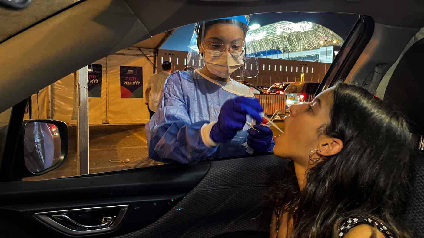 Một nhân viên y tế tiến hành kiểm tra COVID-19 trong quá trình lái xe ở Petah Tikva, Israel. Đất nước đã chứng kiến ​​các trường hợp trở lại mức cao kỷ lục. © Reuters