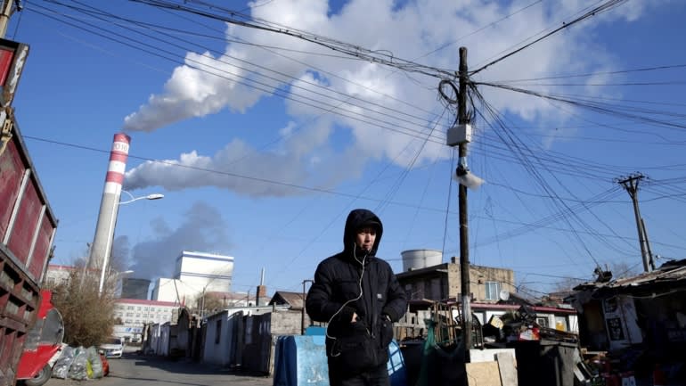 Một người đàn ông đi dạo gần nhà máy nhiệt điện than ở Cáp Nhĩ Tân, tỉnh Hắc Long Giang. Giá than tăng cao, cũng như nỗ lực hạn chế khí thải của Bắc Kinh đã gây ra tình trạng khủng hoảng năng lượng. © Reuters
