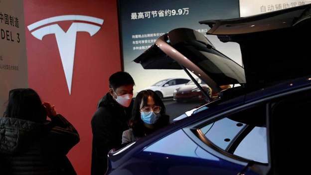 Khách tham quan triển lãm bày tỏ hứng thú với chiếc xe thể thao đa dụng Tesla Model Y do Trung Quốc sản xuất tại phòng trưng bày ở Bắc Kinh