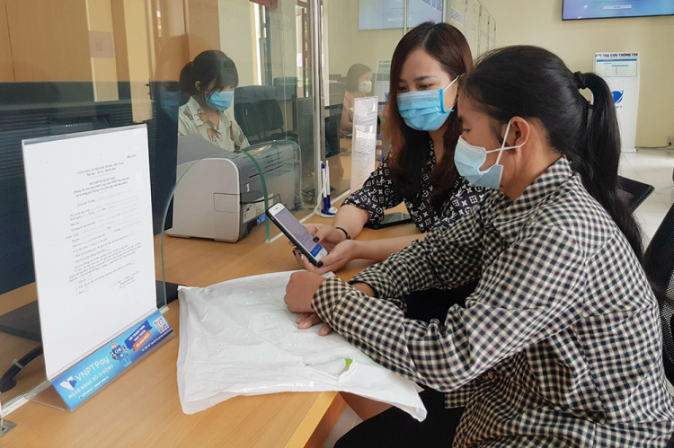 Cán bộ Bộ phận tiếp nhận và trả kết quả UBND huyện Tân Sơn hướng dẫn người dân thực hiện thanh toán trực tuyến
