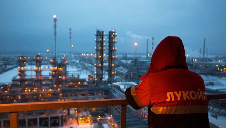 Một nhân viên nhìn ra khu phức hợp khai thác dầu mỏ được chiếu sáng tại nhà máy lọc dầu Lukoil-Nizhegorodnefteorgsintez ở Nga