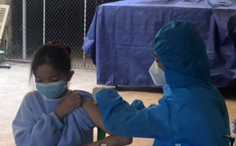 Cán bộ y tế tiêm vắc xin phòng Covid-19 cho trẻ em từ 12 - 17 tuổi tại trường THCS Lý Tự Trọng (TP Hoà Bình).