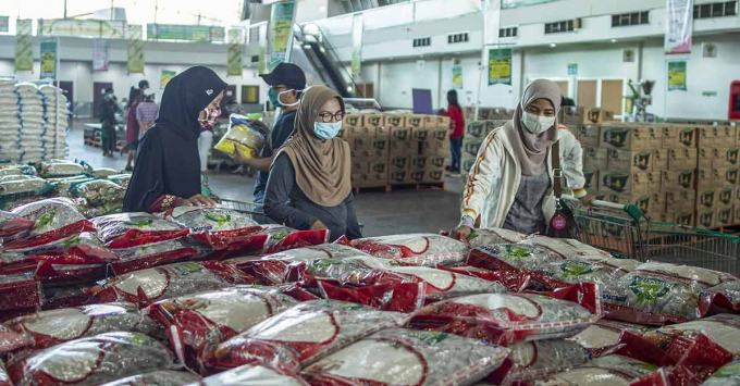 Người dân chọn mua gạo giá rẻ và các mặt hàng tạp hóa khác tại một nhà kho trong bối cảnh bùng phát dịch Covid-19, ở Surabaya, Đông Java, Indonesia