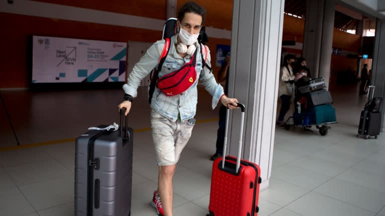 Một khách du lịch chuyển hành lý của mình sau khi đến sân bay quốc tế Bali vào ngày 4 tháng 2. © AP