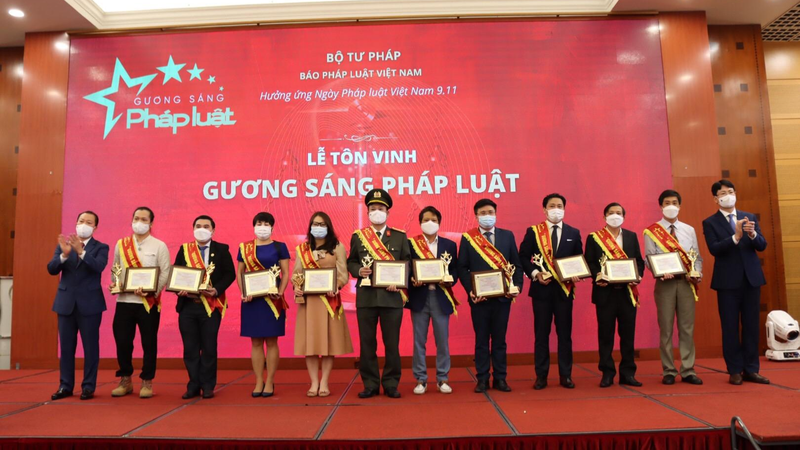 Thứ trưởng Nguyễn Thanh Tịnh (ngoài cùng bìa phải) và Tổng Biên tập Báo Pháp luật Việt Nam Đào Văn Hội (ngoài cùng bìa trái) trao Giấy chứng nhận của Chương trình “Gương sáng Pháp luật” cho các Gương sáng Pháp luật 2021
