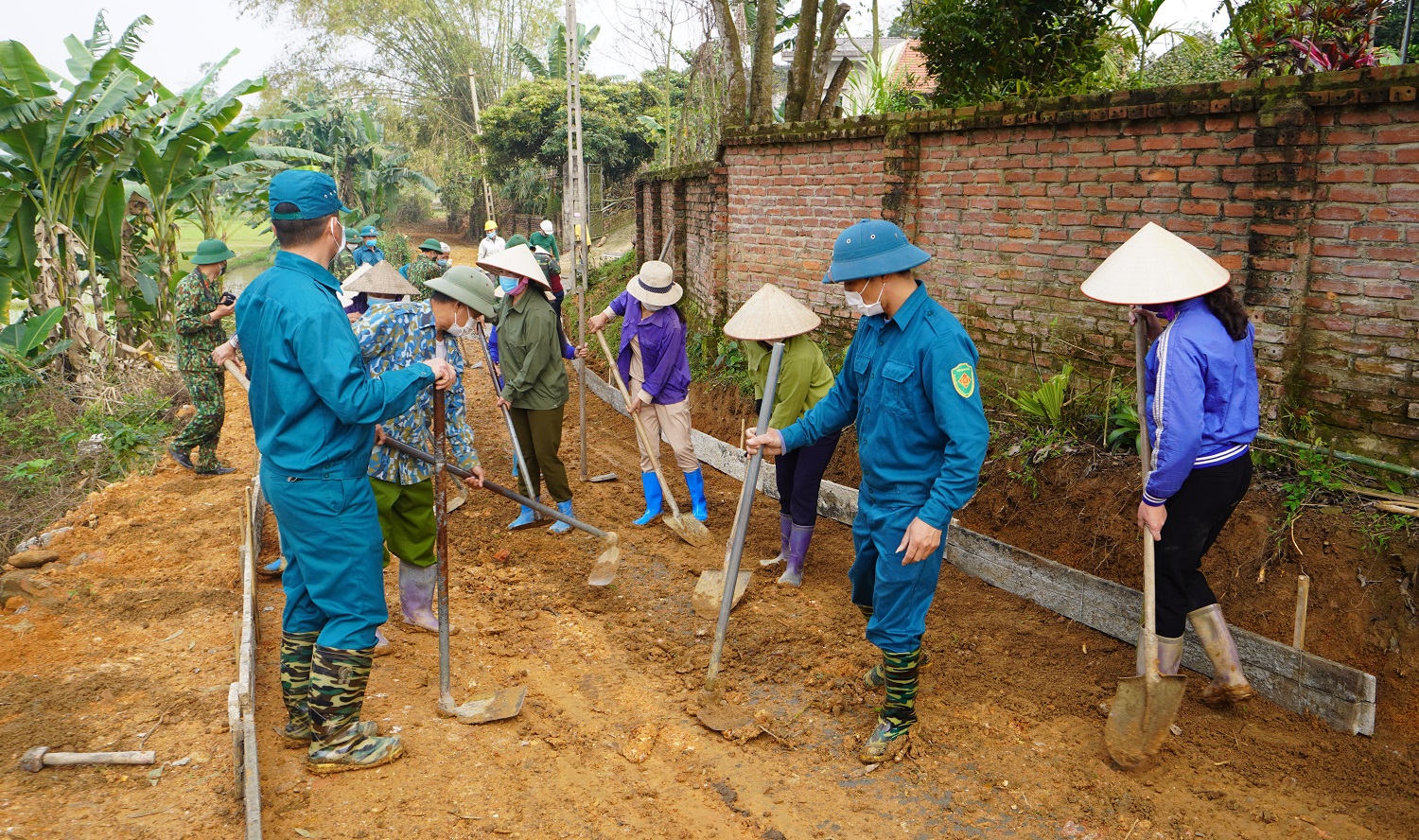 Lực lượng dân quân và nhân dân  tham gia thi công tuyến đường bê tông  tại khu 1, xã Lam Sơn