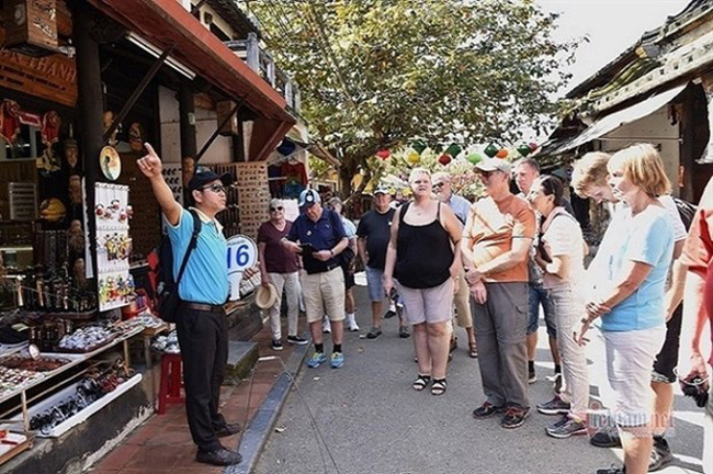 tour guide speaking to a group of int'l tourists in Hoi An in 2019. (Photo: vietnamnet.vn)