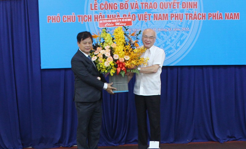 Trưởng ban Tuyên giáo Thành uỷ TP.HCM trao hoa chúc mừng cho ông Trần Trọng Dũng. Ảnh: NGUYỄN YÊN