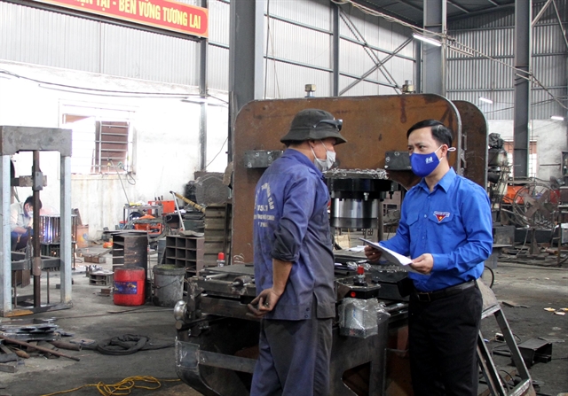 Hồ Xuân Vinh (right) explains the techniques to a worker in Hồ Hoàn Cầu Mechanical Factory. — VNA/VNS Photo Văn Tý