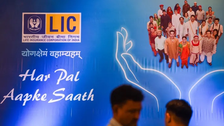 Logo LIC lấp ló phía trên một vài người qua đường ở Mumbai, Ấn Độ vào tuần trước. IPO của công ty trả tiền lớn nhất trong lĩnh vực bảo hiểm nhân thọ trong nước dự kiến ​​sẽ thu về 2,7 tỷ USD trong đợt IPO lớn nhất của đất nước cho đến nay.