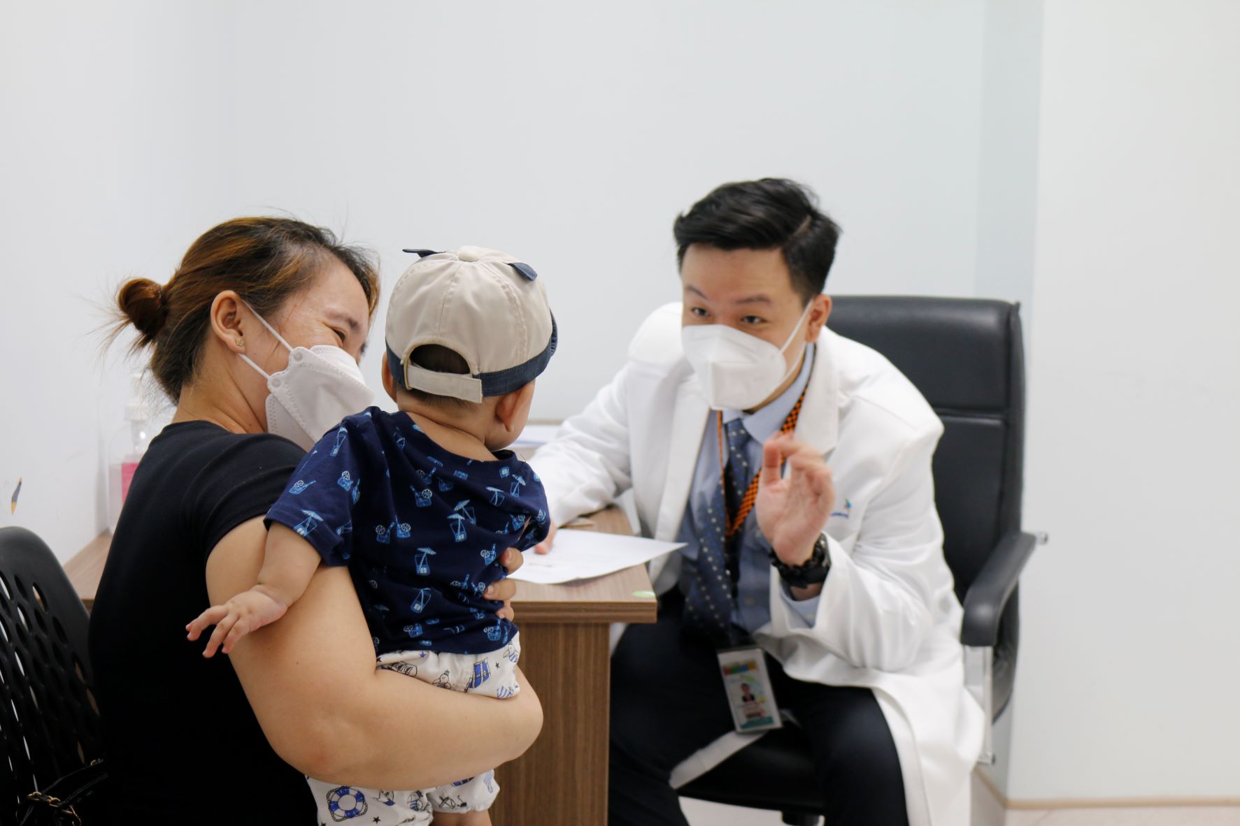 Bác sĩ trò chuyện cùng phụ huynh và em nhỏ tại buổi khám