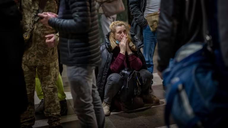 Một người phụ nữ đợi tàu khi cố gắng rời Kyiv. © AP
