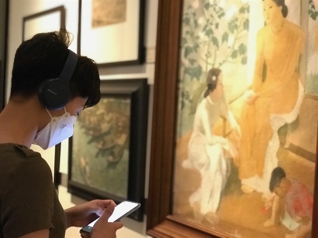 A visitor uses a remote guide app on her mobile at the National Fine Arts Museum. —VNS Photo Lê Hương