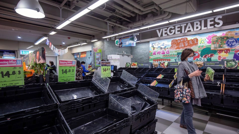 Những người mua sắm dọn sạch các kệ hàng của một siêu thị ở Hồng Kông vào ngày 8 tháng 2 năm 2022. PAUL YEUNG / BLOOMBERG