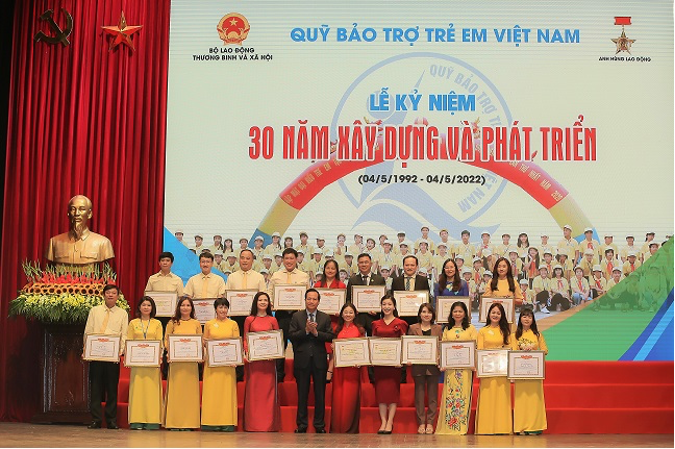 Comrade Dao Ngoc Dung, who was the Minister of Labor, War Veterans, and Social Affairs, posed for pictures with groups and individuals who had done a lot for the safety and care of children.