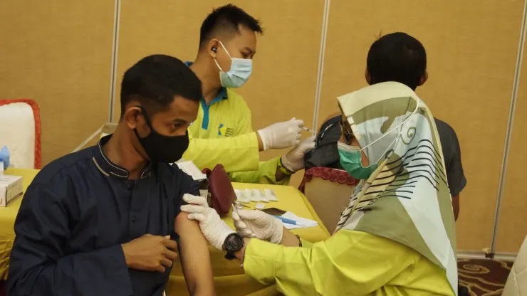 Ấn Độ nổi lên như một nhà cung cấp lớn vắc xin Covid-19, cung cấp cho 75 quốc gia, trong đó có Indonesia, nơi một nhân viên y tế tiêm vắc xin AstraZeneca cho người nhận ở đảo Bintan vào ngày 2/7/2021.