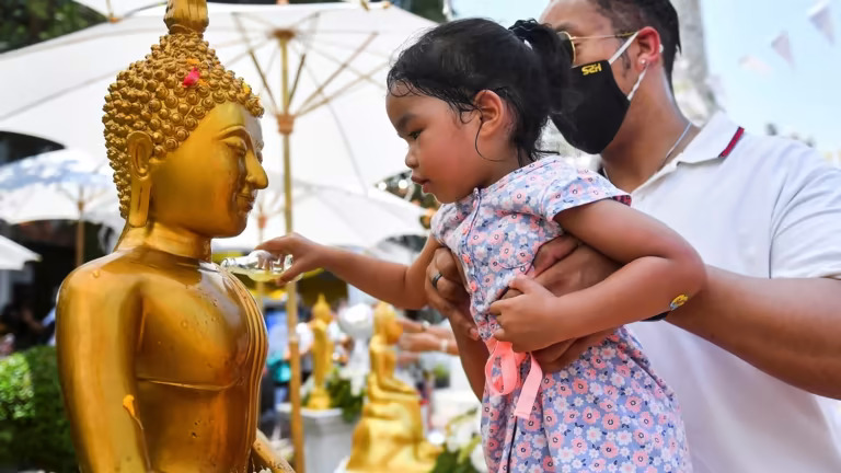 Một cô gái đổ nước lên tượng Phật trong lễ hội Songkran ở Thái Lan. Đất nước này có một đơn vị cảnh sát chuyên trách và các bàn giúp đỡ để hỗ trợ khách du lịch. © Reuters