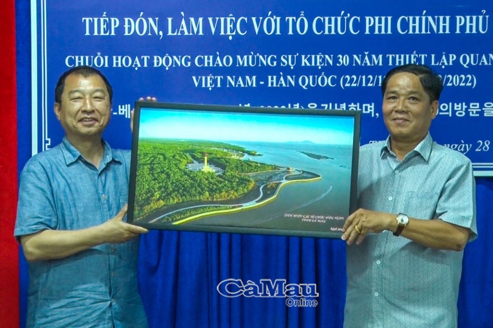 Ông Nguyễn Đồng Khởi (bên phải), Chủ tịch Liên hiệp Các tổ chức hữu nghị tỉnh Cà Mau, trao tặng ông Park Changil món quà là bức tranh về Đất Mũi Cà Mau.
