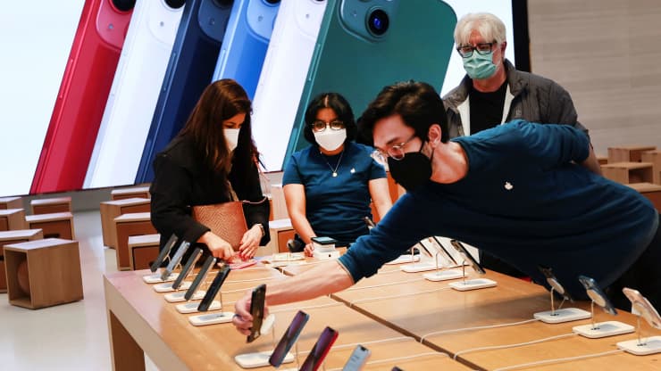 Một nhân viên sắp xếp iPhone của Apple khi khách hàng mua sắm tại một cửa hàng Apple. Mike Segar | Reuters