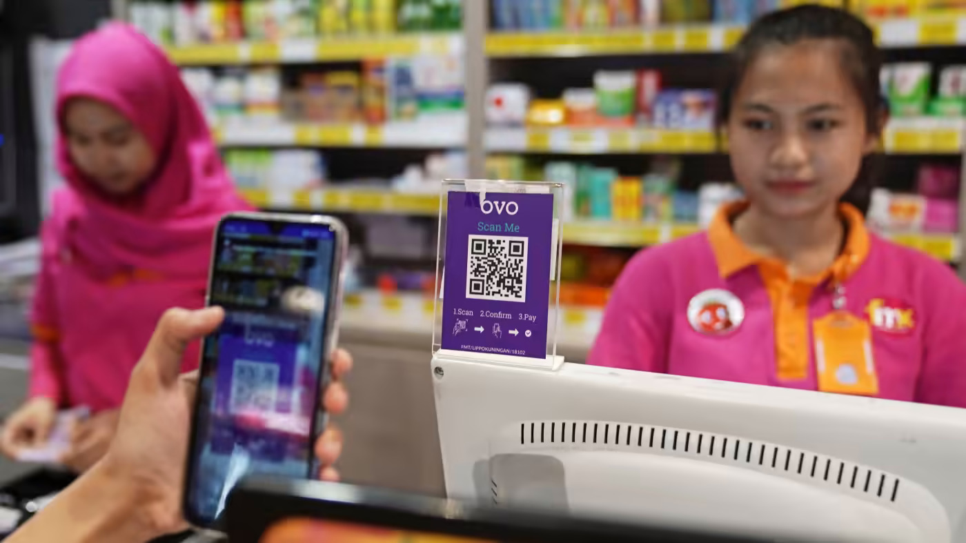Một người mua sắm quét mã QR của dịch vụ thanh toán kỹ thuật số OVO ở Jakarta: Sự kết hợp của các cơ hội mới đang cho phép các công ty mới đạt được quy mô và phạm vi tiếp cận chưa từng có. (Ảnh của Dimas Ardian)