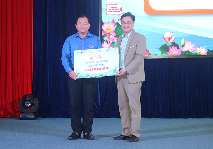 Comrade Doan Kim Thanh - Director of the Center for Young Science and Technology Development (right cover) presented a symbolic board of total support resources for Dong Thap province.