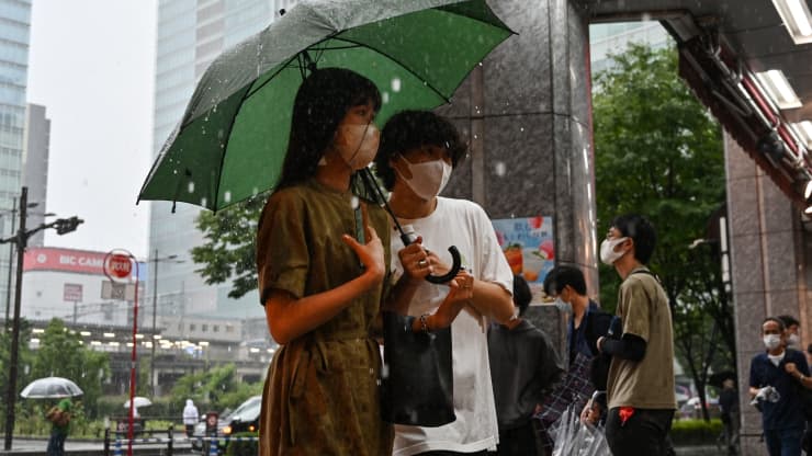 Mọi người tìm nơi trú ẩn khỏi một trận mưa như trút nước ở quận Akihabara của Tokyo vào ngày 13 tháng 8 năm 2022, khi mưa lớn do cơn bão nhiệt đới Meari mang lại đổ bộ vào khu vực này.