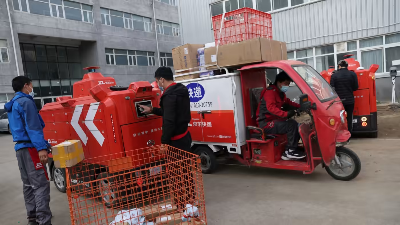 Nhân viên xếp các bưu kiện vào một phương tiện giao hàng tự động tại trung tâm hậu cần thông minh của JD.com ở Bắc Kinh. © Reuters