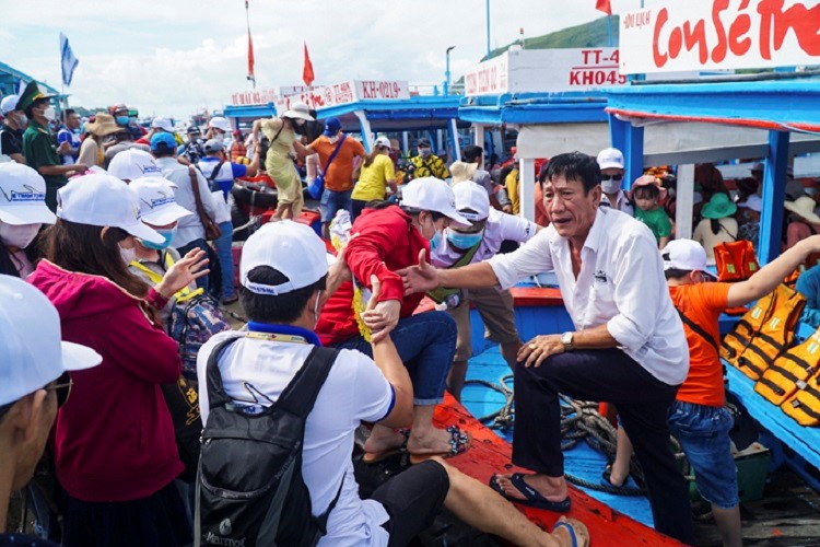 Tourists disembark from the boat to explore the water and islands of Nha Trang Bay.