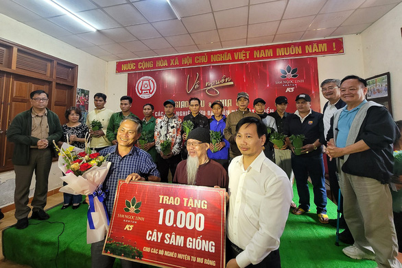 Đại diện Công ty Cổ phần Sâm Ngọc Linh Kon Tum (bên phải) trao cây sâm giống cho đại diện UBND huyện Tu Mơ Rông
