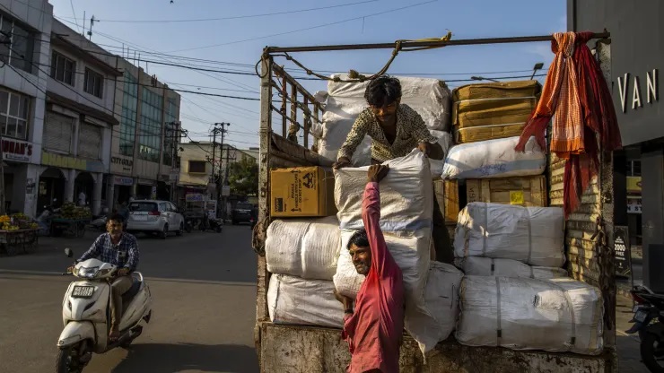 Công nhân bốc dỡ hàng hóa từ một chiếc xe tải tại khu chợ chính ở Gandhidham, Ấn Độ. Ashok Hinduja, Chủ tịch Tập đoàn Hinduja, Ấn Độ, cho biết Ấn Độ là một thị trường tuyệt vời và là “điểm đặt cược tốt nhất” trong nền kinh tế toàn cầu.