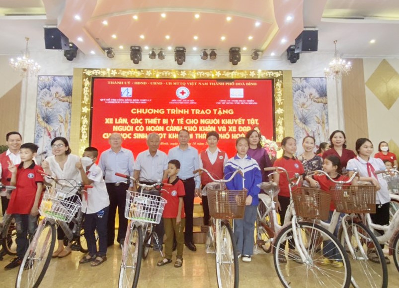 Các nhà tài trợ và đại diện Hội Chữ thập đỏ thành phố trao xe đạp cho học sinh nghèo trên địa bàn.