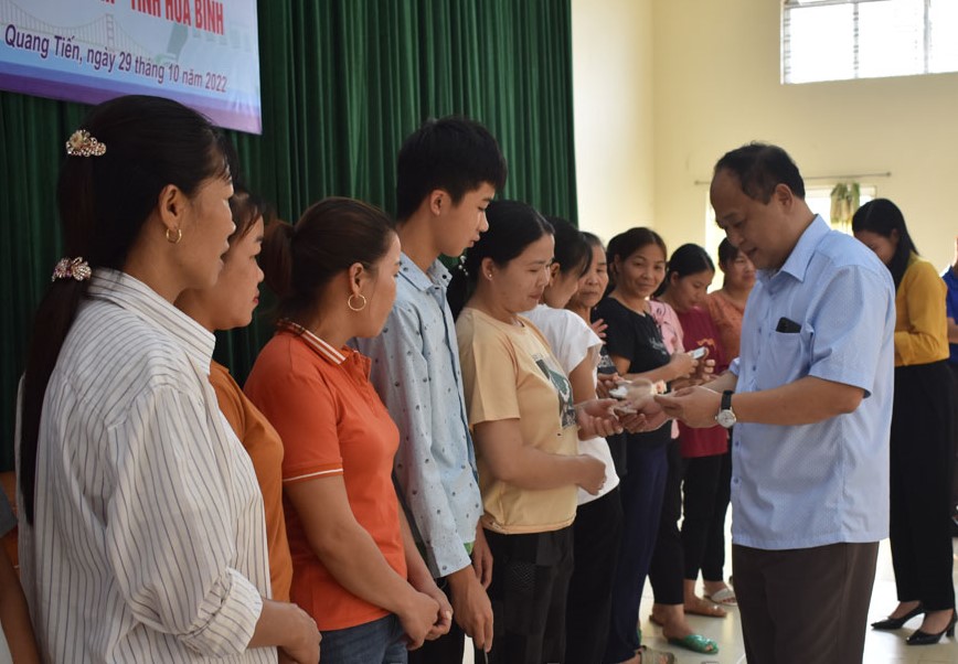 Lãnh đạo BHXH tỉnh Hòa Bình và đại diện Ban chỉ đạo thực hiện chính 
sách BHXH, BHYT thành phố Hòa Bình trao thẻ cho các hộ nghèo ở xã Quang Tiến