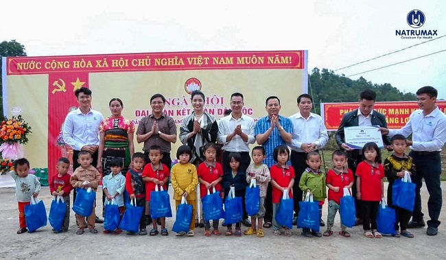 Bà Nguyễn Mai - TGĐ Natrumax Việt Nam (người đứng thứ tư bên trái) trao quà cho các em nhỏ có hoàn cảnh khó khăn